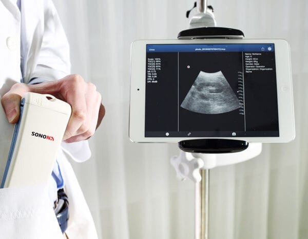 A doctor is holding a tablet in front of an ultrasound image.