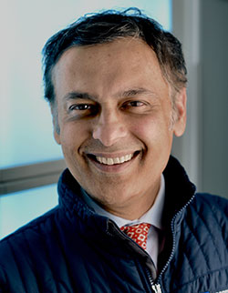 A man in a blue jacket smiling for the camera.